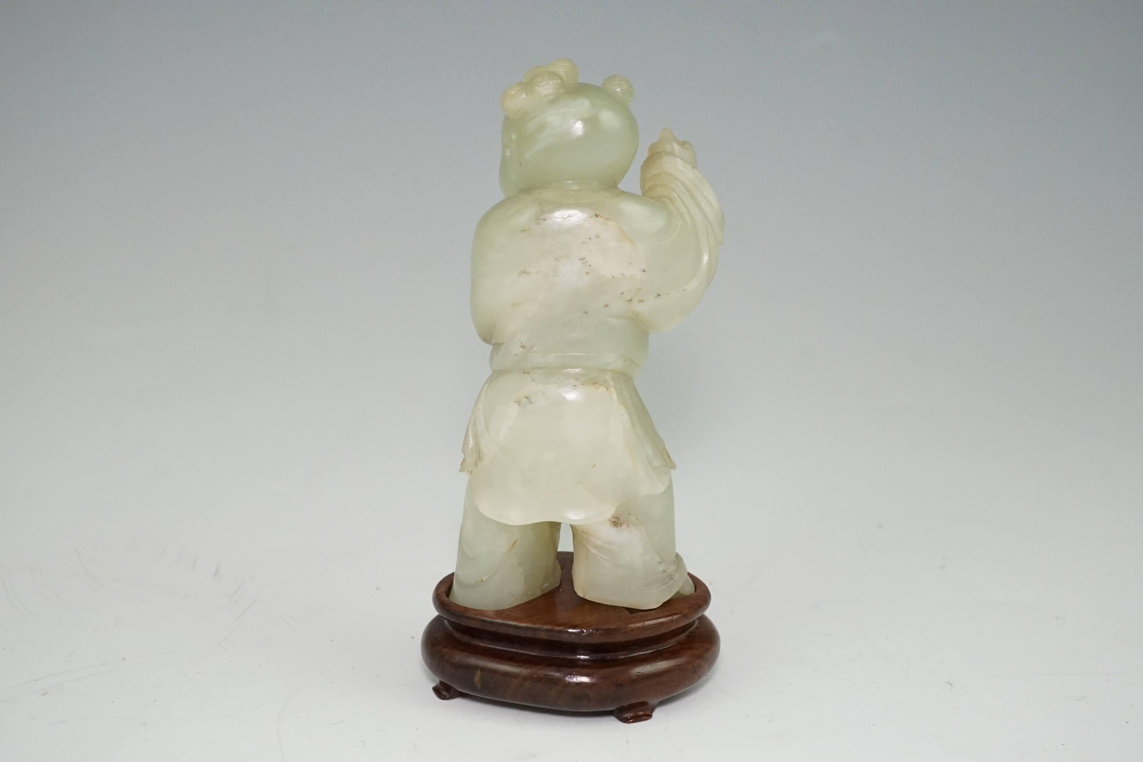 A Chinese pale celadon jade figure of a boy, 18th century